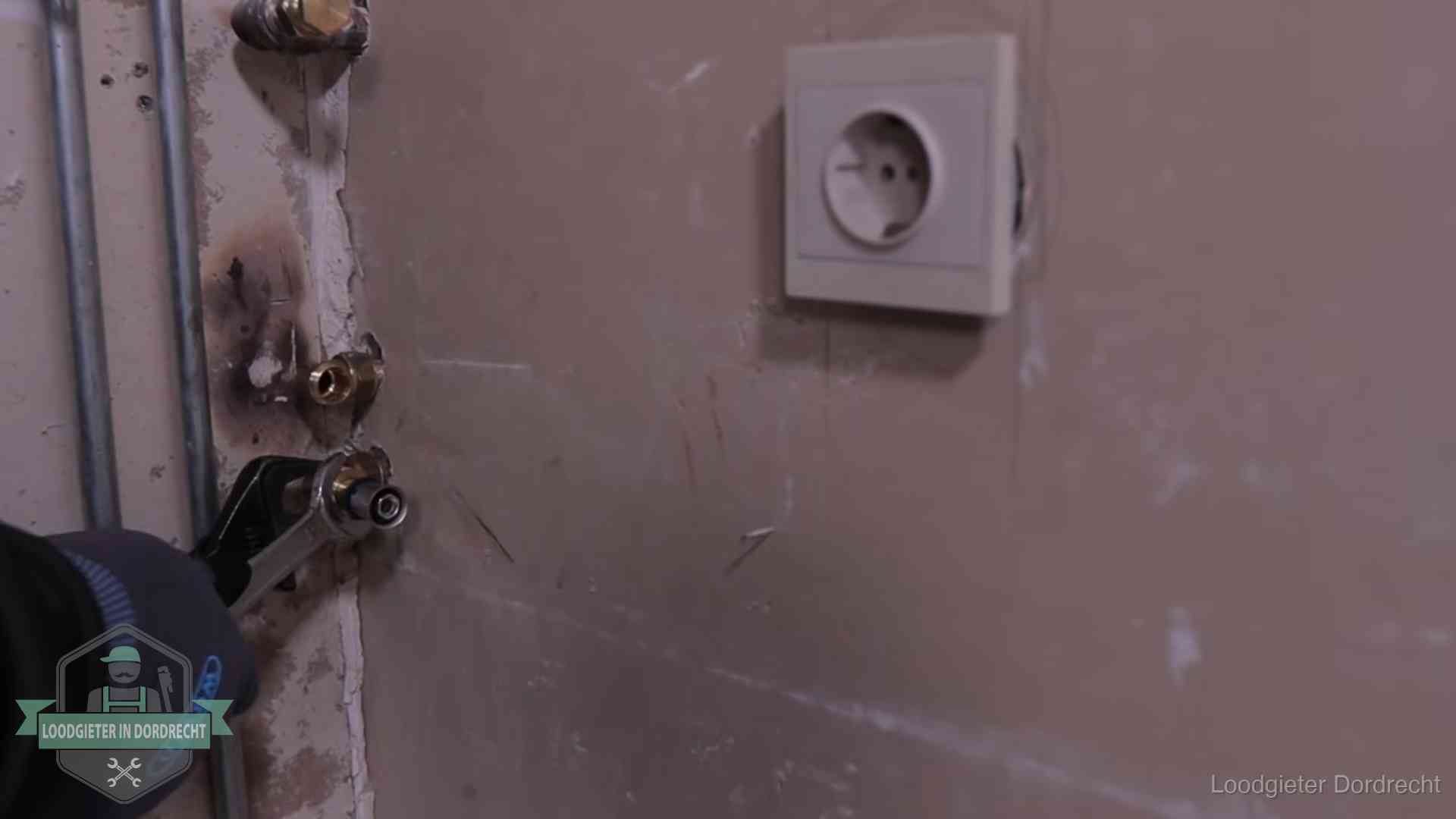 Monteur draait een perskoppeling vast op een leidingaansluiting in Dordrecht