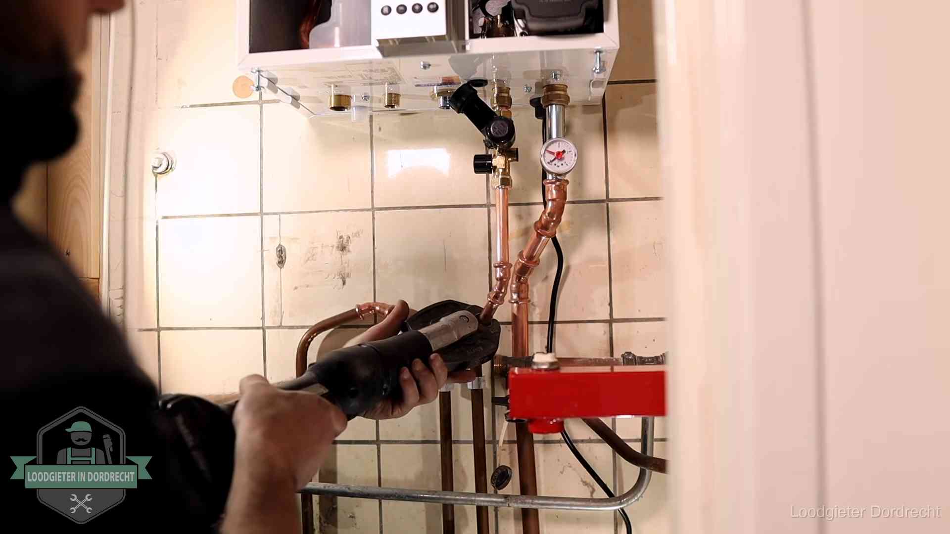 Cv-ketel onderhoud in Dordrecht Monteur werkt aan de leidingen onder een cv-ketel in Dordrecht
