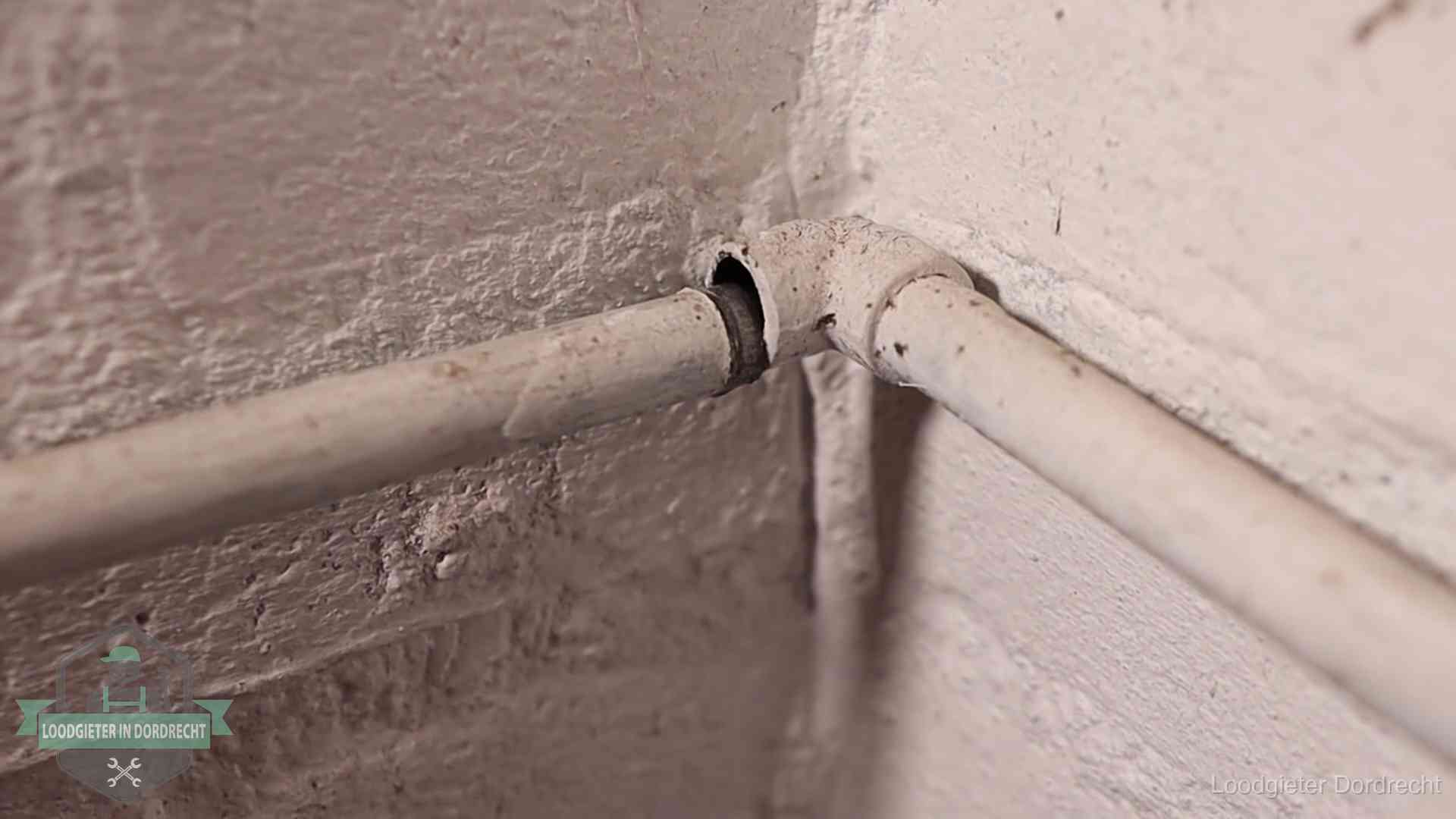 Oude waterleidingen en verborgen lekkage in Dordrecht Oude geverfde waterleiding met een losliggende fitting in een woning in Dordrecht