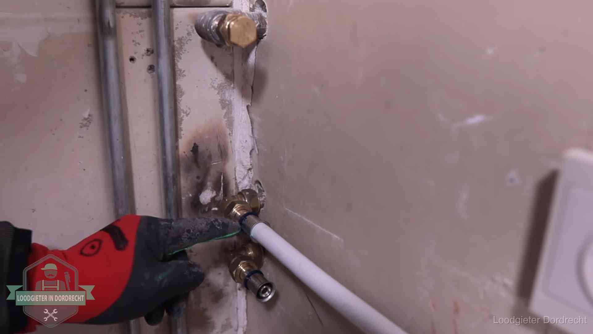 Loodgieter wijst de persfitting op nieuwe muuraansluitingen aan in een woning in Dordrecht