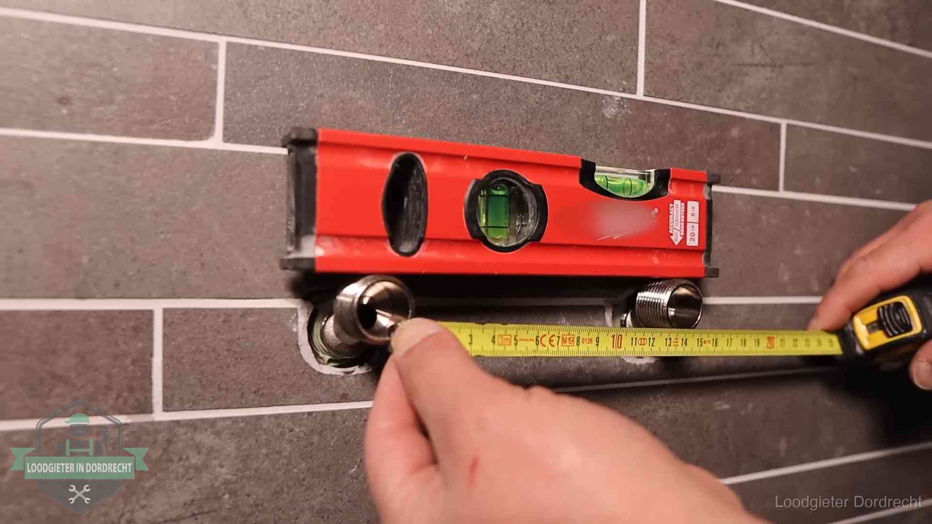 Waterpas en duimstok bij kraan-aansluitpunten in een badkamer in Dordrecht