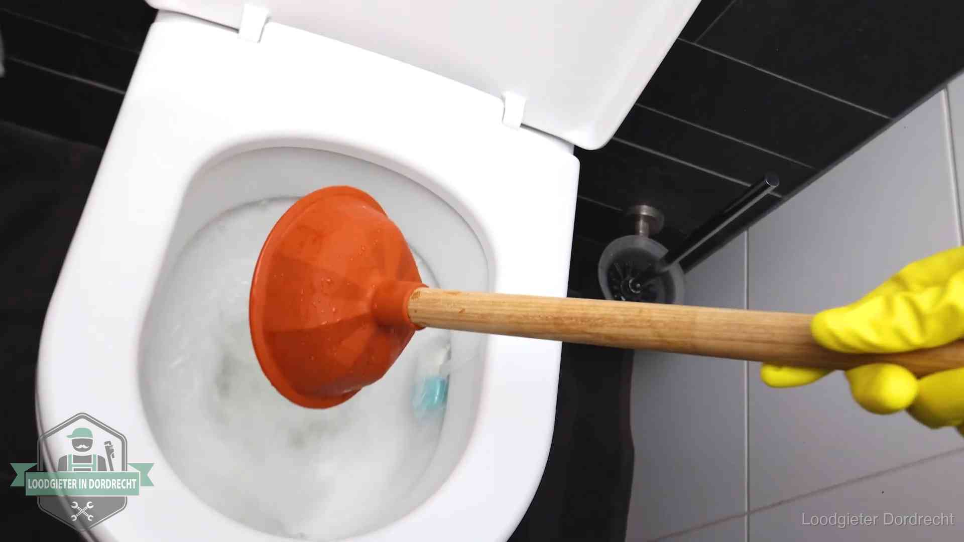 Wc ontstoppen met de plopper in Dordrecht Plopper wordt in de wc-pot gedrukt bij het ontstoppen van een toilet in Dordrecht