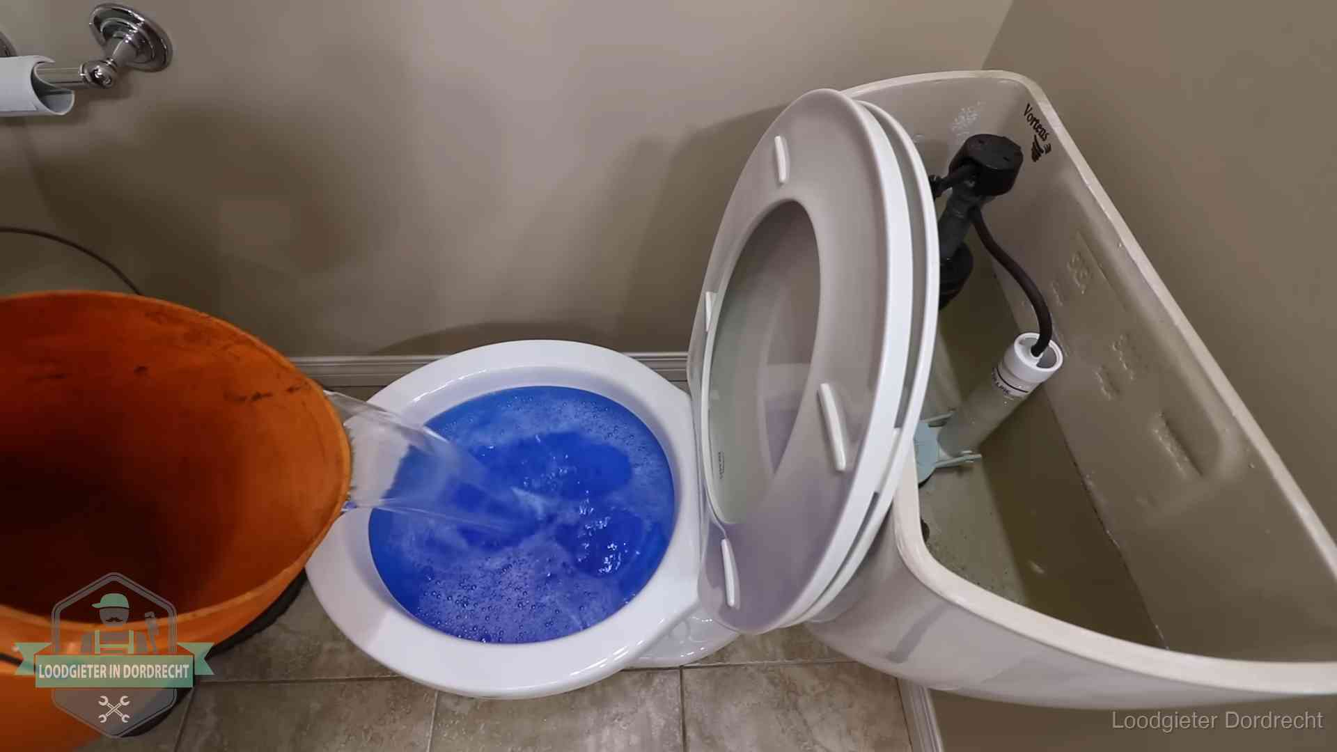 Water komt omhoog in de wc in Dordrecht Water bij de wc-pot wordt met een emmer weggewerkt om schade te beperken in Dordrecht